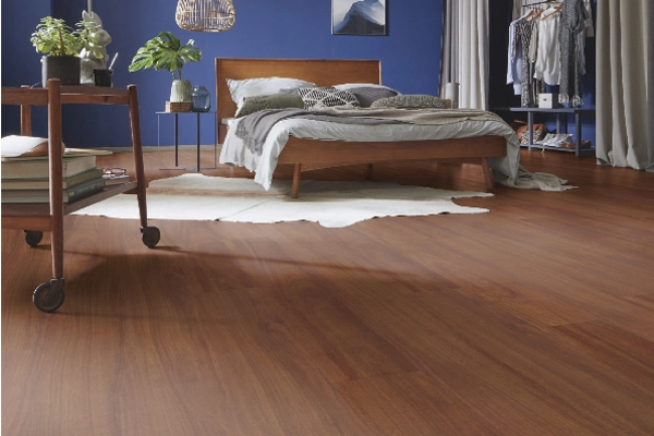 Bedroom with blue walls and warm wood flooring.