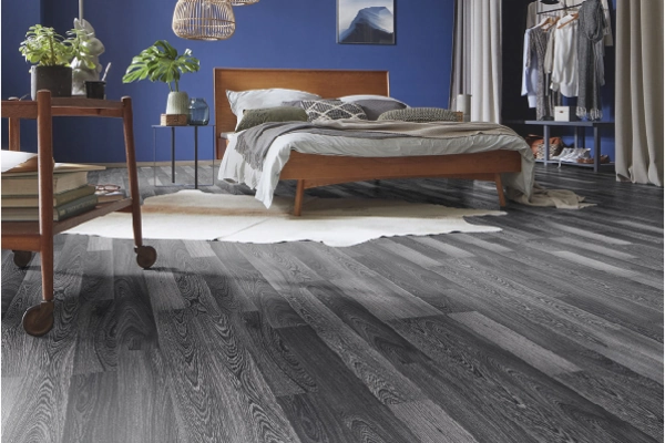Modern bedroom with dark gray wood-look flooring.